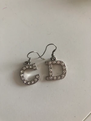 Örhängen  - CD silvriga örhängen med strass (ej äkta)