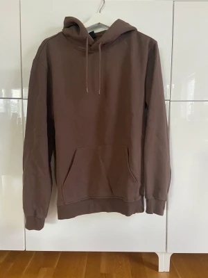Basic brun hoodie - Brun hoodie med mjukt material i relaxed fit. Har använts ett fåtal gånger.
