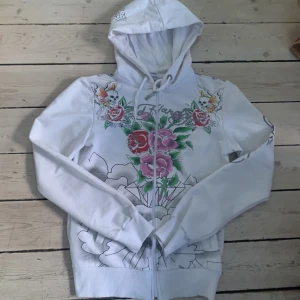 Ed Hardy Hoodie  - Hej! Säljer nu denna feta ed Hardy tishan. Den har stort snyggt tryck på ryggen och mindre där fram. Rhinestones också. Den är i bra skick skriv om ni undrar över något eller är intresserade.