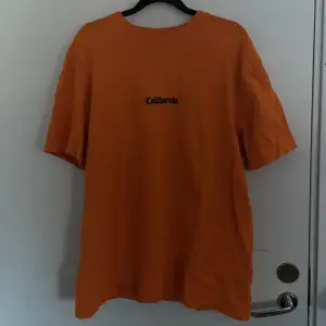 En orange T-shirt med ett coolt tryck.