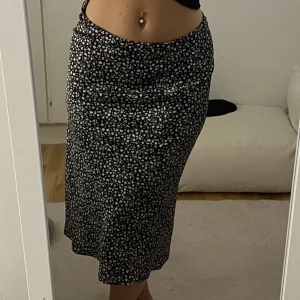 Blommig kjol i satinmaterial  - Kjol från H&M. Aldrig använd endast testad. Storlek 36.