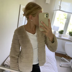 Jacka  - Jättefin och mysig beige pälsjacka från Gina Tricot. Sparsamt använd och väldigt bra skick. Lent och mjukt tyg med fint mönster. Lagom varm och passar vår, sommar och höst. Säljer eftersom den tyvärr inte kommer till användning. Passar xxs-s