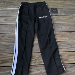 Palm Angels Byxor - Säljer dessa Palm Angels byxor. Endast använda ca 5 gånger. Har lapparna kvar och fint skick. Säljer billigt eftersom är osäker på om de är äkta! Kan skicka fler bilder i DM. Perfekt byxorna i höst / vinter och riktigt sköna! ⭐️👀🙌