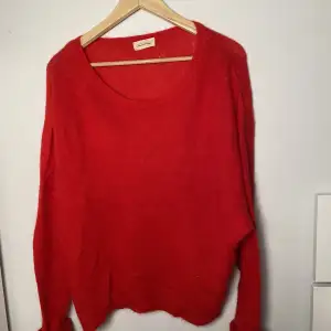 En röd stickad tröja från American Vintage som är super mysig. Den är i super skick( nästan aldrig använd) och jättebra kvalitet. Den kan bäras off-shoulder om man vill också. Passar allt emellan S-L beroende på hur man vill att den ska sitta❤️