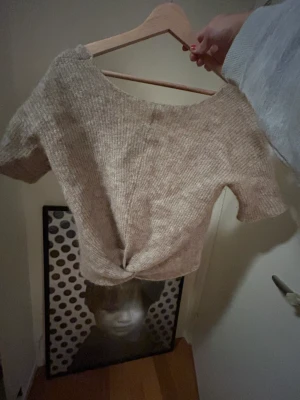 Kortärmad stickad tröja  - Den här så mysiga ull stickade tröjan är så gullig som är kortärmad och har en liten gullig Knut där fram, är även super söt bakifrån med öppen rygg🧡🤪