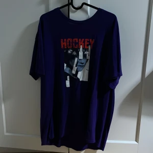 Hockey Tshirt  - Säljer nu denna Tshirt från märket Hockey skateboards. Tröjan är använd några gånger och är då i bra skick. Storleken är Xl rekommenderas för de som gillar oversized. Orginal pris 500kr Skriv vid eventuella frågor.