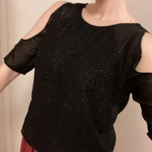 Glittrig Topp - En svart topp som glittrar och har unik design med öppna armar 🖤  Pris kan diskuteras 🙌