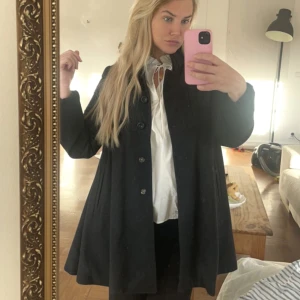 Kappa Vero Moda - Jättefin kappa från Vero Moda. Blair Waldorf style. A-skuren kappa. ❣️ Svart med lite gråspräckligt.