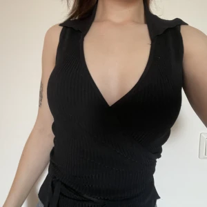 Knyttopp - Fin lång knyttopp med krage. Den är ribbad och har V-ringning. 