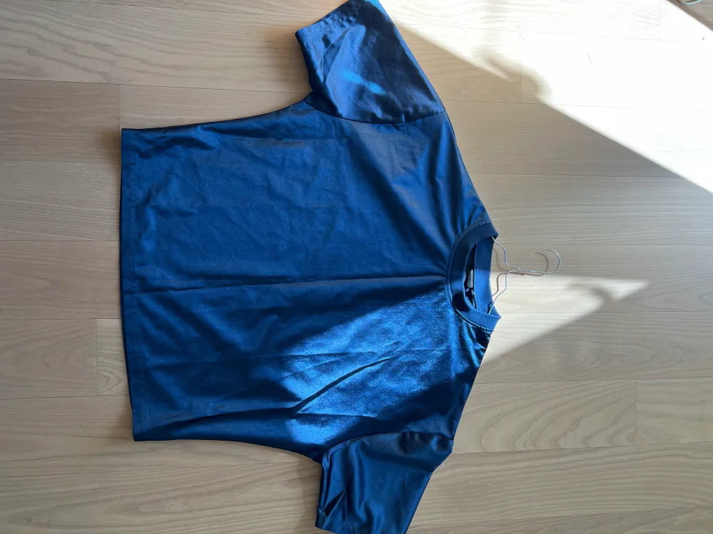 Mint condition, only worn once, blue shimmery tee. chest: 96-102cm. 100% polyester . T-shirts.