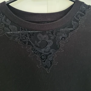 Asos klänning  - Svart färg 100% bummol klänning från Asos med fina spets runtom halsen och längst när korta ärmarna. 