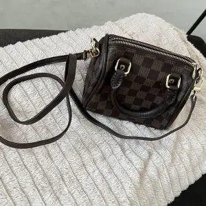 En jätte fin kopia Louis Vuitton speedy damier ebene i brun färg  axelremsväska. Helt nytt. Inga repor eller liknande. Säljs den eftersom rensar min garderob som jag inte använder🌸   Väskans mått är 17x15x11 cm 