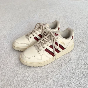 Adidas-sneakers - Benvita sneakers med röda ränder, från Adidas! Unik modell, köpta secondhand men ser väldigt oanvända ut! Tyvärr för små för mig 🤍