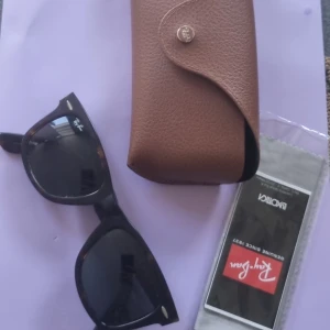 Ray-Bans  - Äkta Ray-Bans. Lite slitna i bågen men inte i glasen. Fodral och oöppnad putsduk finns. Ej kvitto tyvärr. Grå/brun spräckliga i färgen 