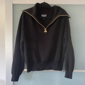 Stickad tröja från Barbour - Svart stickad tröja från Barbour med halvzip. Varsamt använd utan defekter. Nypris 1800kr