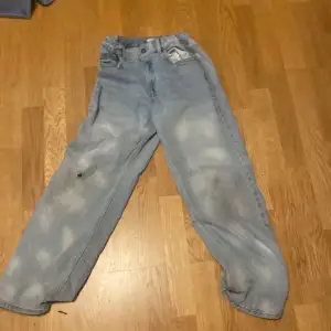 vålanvända jeans med med två hål inge permanenta fläckar
