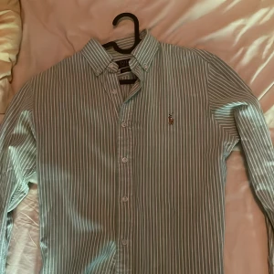 Ralph Lauren skjorta grön vit randig - Tja gjorde en resning till hemma och hittade fler kläder som är för små bland annat denna grön vita Ralph Lauren skjorta. Skjortan är verkligen skitsnygg och var min favorit när den passade