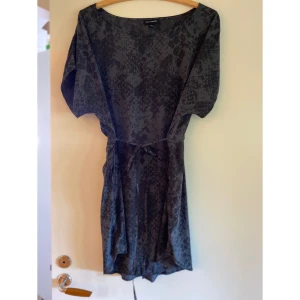 Klänning - Storlek 40/42, knytning i midjan som gör att man får fin figur. 