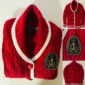 Henri Lloyd stickad kofta - Henri Lloyd, stickad kofta Klassisk modell, klar röd med vita detaljer på slag och ärmar. Hög stå krage som kan vikas ned   Skick, knappt använd  Nypris 2500kr