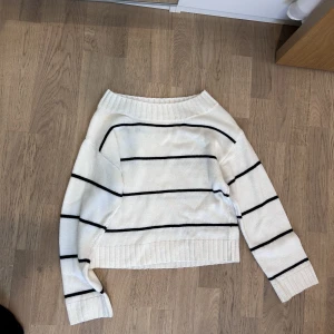 Somrig tröja / stickad tröja  - Randig långärmad stickad tunn tröja i svart vitt. Lite off shoulder. Perfekt över en lång vit kjol/linne byxor, shorts, eller klänning! 