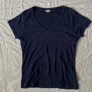 Mörkblå T-shirt med snygg pärldetalj, köpt secondhand och har en liten fläck strax under nyckelbenet men inget som stör!! Annars i bra skick🌷