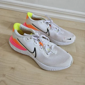 Nike skor - Snygga jympaskor från Nike. Vita med detaljer i neon. Skorna är knappt använda och i mycket bra skick! Storlek 39