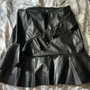 Skinn Kjol  - Säljer denna fina skinn kjolen från Bik Bok, använd endast 1 gång därav ny skick, säljer pågrund av att att jag inte använder den längre. 