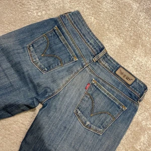 Vintage lågmidjade Levis jeans  - Bud :400 så snygga Levis jeans i den perfekta färgen! Modellen 570. För små för mig tyvärr. Lågmidjade och bootcut!! Midjemåttet rakt över : 38 cm. Innerbenslängden : 71 cm 💗💗💗
