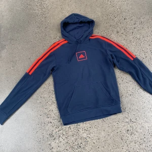 Hoodie adidas - Snygg Hoodie i marinblå färg med neonorange adidasränder. 