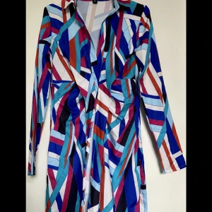 Skjortklänning - Från: Boohoo Namn: Abstract print tie front shirt dress Säljer för att den var för tajt runt höfterna och är inte speciellt stretchig, så rekommenderar inte någon med lite höfter att köpa den.  Aldrig använd. 