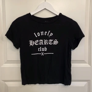 Söt t-shirt  - Svart tunn och kort t-shirt med tryck ”lonely hearts club” på. Används ej längre men i bra skick och sitter fint. 