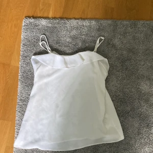 Vitt linne  - Ett vitt linne från H&M, storlek 34(xs) tunnt och luftigt linne, bra i storleken gjort av polyester 