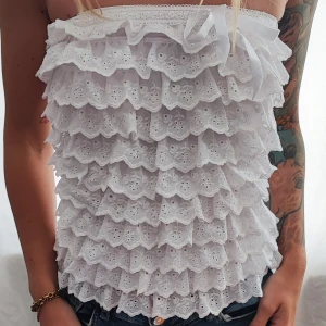 Sött linne med volanger. - Från White Design By Pink. Står ingen storlek men passar XS-S. Bomull.