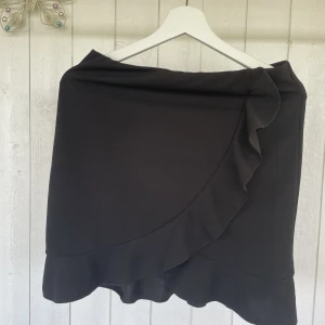 Kjol - En svart omlottkjol som nästan aldrig är använd.  Säljs då den inte iommit till användning. 