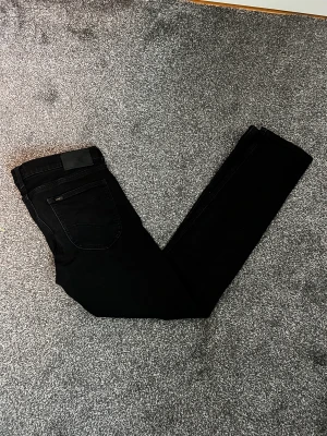 Lee, LUKE - Jeans slim fit - Lee jeans som har blivit för små. Näbbstövlar några fåtal gånger men inte min stil längre! Storlek: W30/L32 Färg: Svart Material: 98% Bommul 2% Elastan med demon tyg 