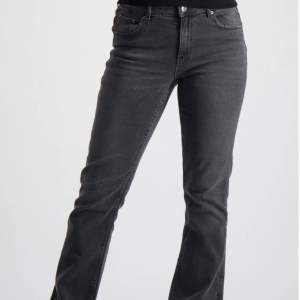 Svart/mörkgrå jeans, syns dåligt på bilden men de är bootcut. 