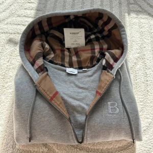 Burberry kofta - Säljer min helt nya burberry hoodie som är helt oanvänd. Detta är en väldigt eftertraktad hoodie som är svår att få tag på. Kvitto och påse från butik ingår såklart. Butiks pris är 750€ vilket motsvarar 8900kr