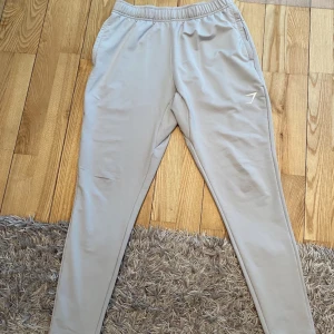 Gymshark träningsbyxor  - Gymshark träningsbyxor i strl S, superfint skick. Som ny. Endast använd fåtal gånger. Dragkedja vid fickorna och snören vid insidan av midjan.