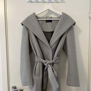 Mycket fin grå kappa med luva. Använt endast 1 gång. Storlek 38 men passar perfekt för mindre storlekar också.