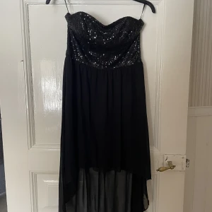 Klänning med paljetter  - Klänning med paljetter.  Kort fram och längre bak. 