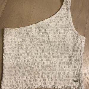 Topp  - Plagget är aldrig använt. Den vita somriga toppen har ett axelband🤍