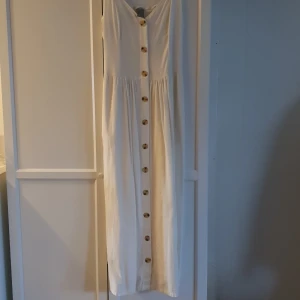 Vit linneklänning  - Vit linneklänning med knappar fram och fickor