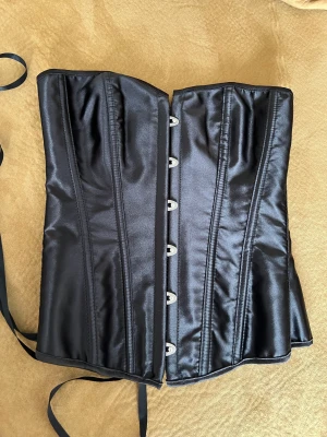Svart korsett - Svart korsett. Sista bilden e exakt samma fast i brun så man kan se hur den ser ut på 