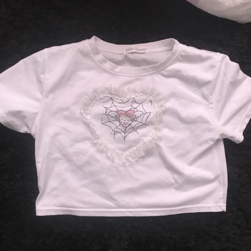 Hello Kitty tshirt med hjärtspets<3 strl xs, köpt på plick men inte direkt min stil :) vid frågor eller fler bilder skriv gärna <3. T-shirts.