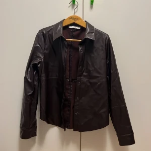 Over-shirt - Skjorta/overshirt/jacka i vinrött fake-skinn. Jag har använt den typ tre gånger som en overshirt över ett linne/t-shirt. Den är ganska varm så hade lika gärna kunnat passa perfekt som en jacka nu till våren!  Storlek S💕 