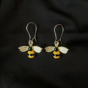 Örhängen med bin🐝  - Örhängen med berlocker i form av bin. Vid beställning får du själv välja vilken typ av krokar du föredrar (se bild 2 och 3). Så matchar jag dem med berlocken. Frakt tillkommer!🐝