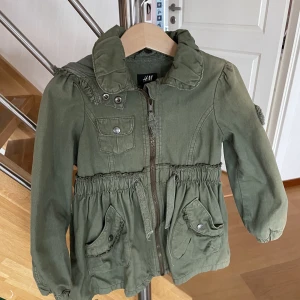 Khaki grön jacka storlek 104 - Fin khakifärgade jacka i storlek 104 i nyskick!