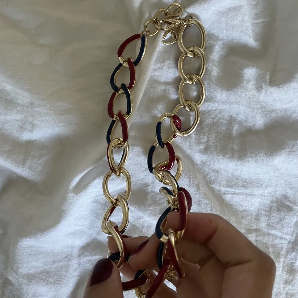 Säljer denna guldkedja med marinblåa och röda detaljer går att använda som halsband och armband❤️. Accessoarer.