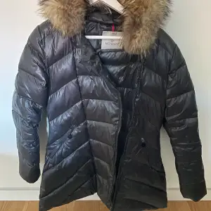 Moncler jacka. Vet ej riktigt om den är riktig eller inte eftersom jag har fått den. Dragkedjan är dock trasig eller trög men går nog att fixa. Annars är den hel! Jackan är lite längre i modellen. Storlek 7 men tycker den sitter som en xs/s