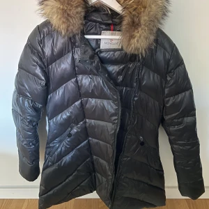 Monclerjacka - Moncler jacka. Vet ej riktigt om den är riktig eller inte eftersom jag har fått den. Dragkedjan är dock trasig eller trög men går nog att fixa. Annars är den hel! Jackan är lite längre i modellen. Storlek 7 men tycker den sitter som en xs/s